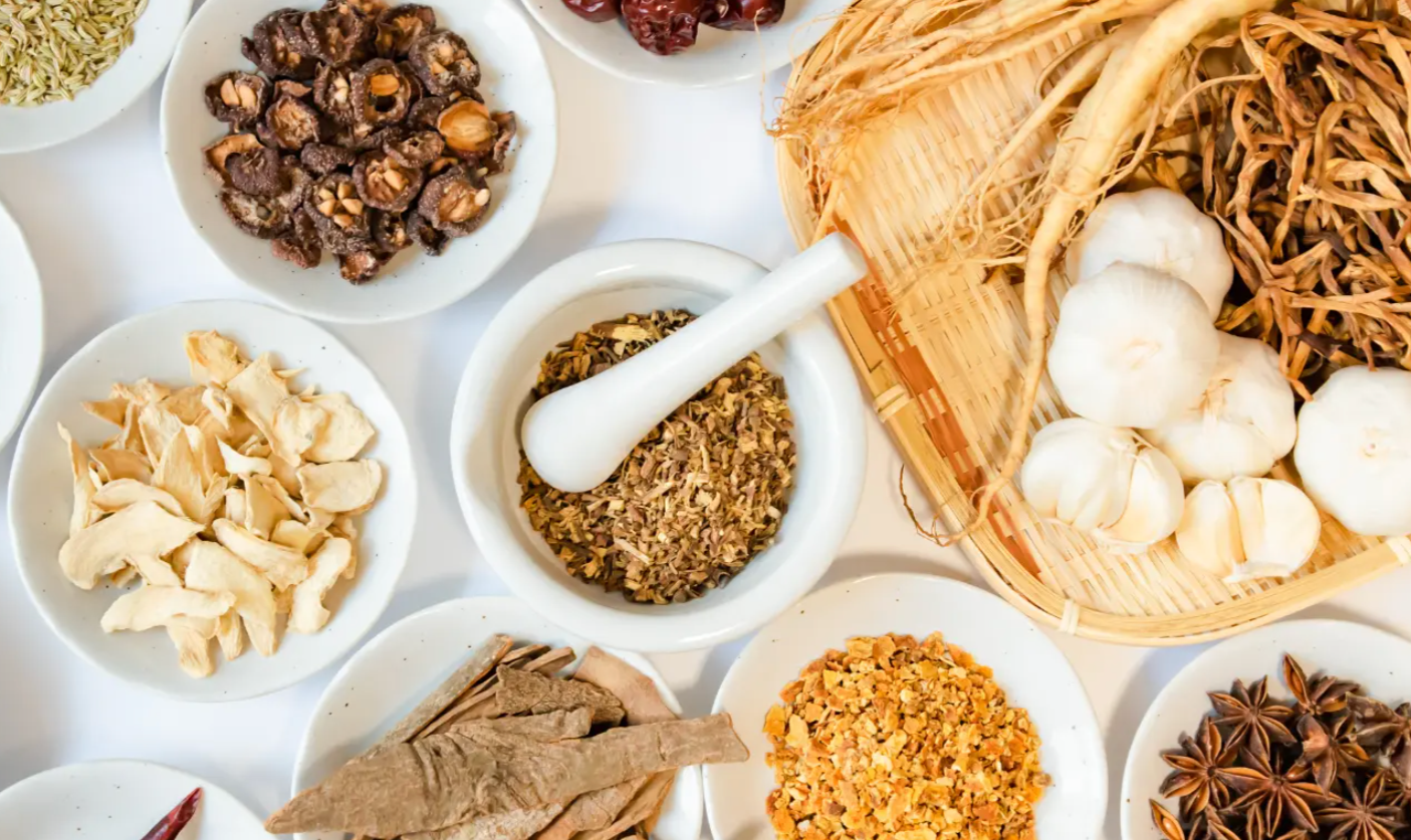 Assorted medicinal herbs and spices on a white surface
