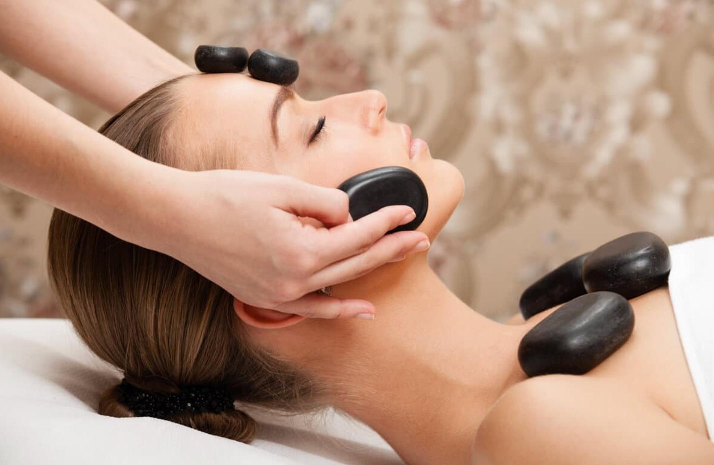 Woman receiving a hot stone massage with a blurred background
